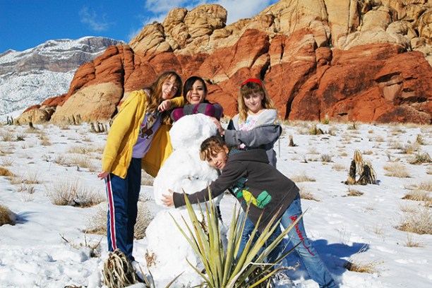 a group of people standing on top of a snow covered mountain